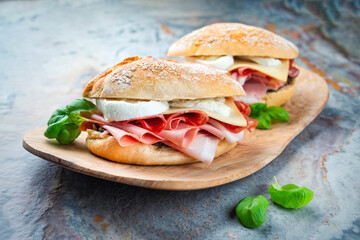 Traditional New Orleans muffaletta sandwiches with mortadella, salami and provolone cheese served...