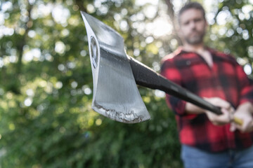 Brutal lumberjack. Lumberjack style. Man woodcutter with axe blade. Axe in man hand chopping wood....