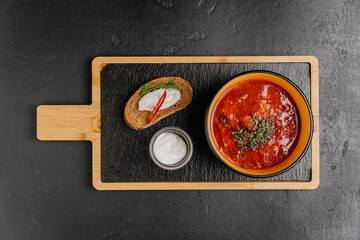 Spicy borscht soup with sour cream and rye bread, a traditional Eastern European comfort dish