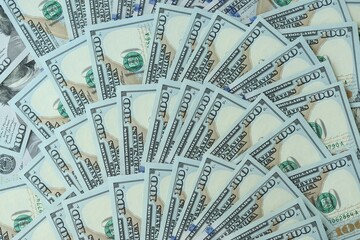 Many hundred dollar bills new banknotes in big pile under the natural light