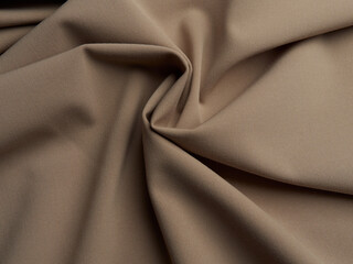 Beautiful folds of beige fabric. High-quality texture of beige fabric.