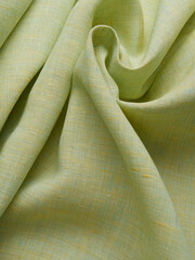 Background - new yellow-green linen fabric. High-quality texture of expensive fabric.
