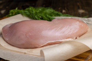 a piece of fresh chicken meat in close-up lies on paper