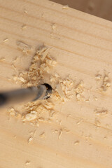 metal drill bit and pine wood board during operation