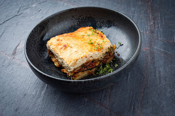 Traditional Greek moussaka with beef mince, eggplant and bechamel sauce served as close-up in a...