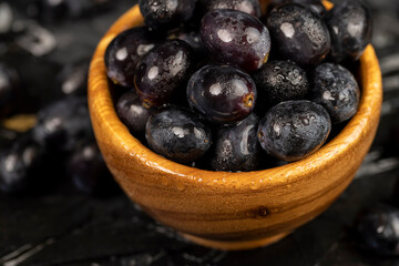 fresh grapes are lying on black paper