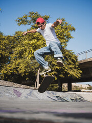 Young skateboarder performing trick at urban skate park