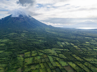 Lush landscape with volcano surrounded by greenery at dawn