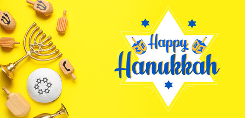 Hanukkah composition with dreidels, kipa and menorah on yellow background