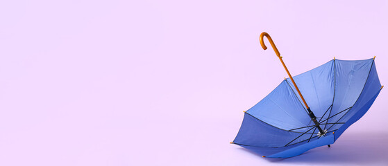 Blue stylish umbrella on lilac background