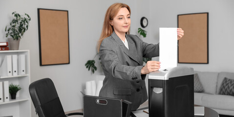 Adult secretary destroying paper sheet using shredder in office