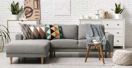 Grey couch with stylish cushions in living room