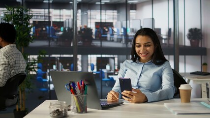 Fototapeta premium Indian employee engages in an online meeting with her team, discussing project briefs and upcoming deadlines. Using video call to ensure seamless communication and time management. Camera A.