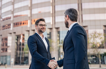 Fototapeta premium Businessmen dealing outdoor. Partnership success. Celebrate business partnership. Two businessmen partner celebrating business deal. Successful partnership in business deal. Business support