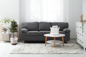 Cozy sofa, coffee table and houseplant in living room