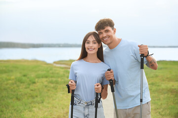 Young couple training with walking poles outdoors