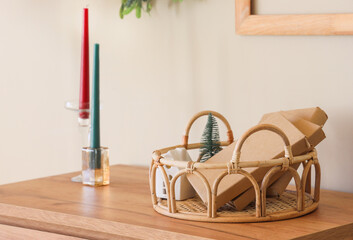 Candles and tray with books on chest of drawers on room. Christmas celebration. Closeup