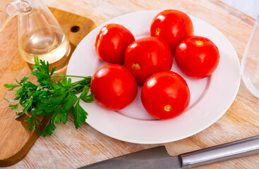 Fresh juicy organic tomatoes on wooden kitchen table