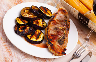 Appetizing fried pork shoulder with eggplant served at plate
