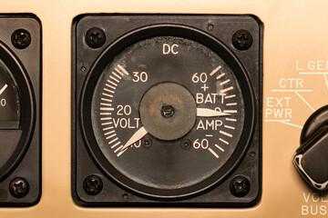 Analog dial, a voltmeter, displays remaining system power in volts. Shows electrical load draw in...