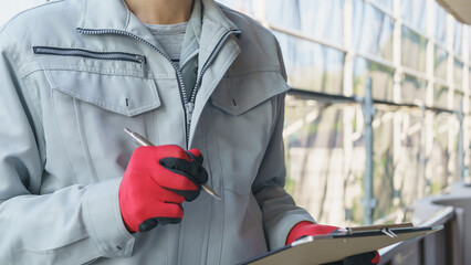 修繕工事の足場の点検をする作業服の男性