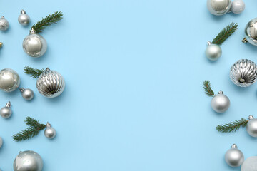 Frame made of Christmas balls and fir branches on blue background