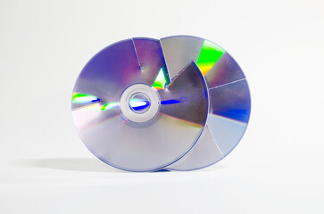 Two cut cd roms next to each other in vertical position, representing the concept of data protection and recycling.