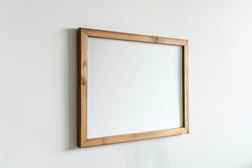 Empty wooden picture frame hanging on a white wall.