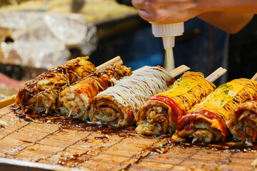Okonomiyaki, Japanese pizza, wrapped on a stick, skewered, a new trend that is selling in the Thai market.