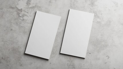 Two blank vertical rectangle menu or price list mockups with subtle shadows positioned diagonally on a neutral light grey concrete background Flat lay perspective