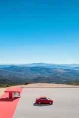Naklejka premium Red Car at Scenic Overlook with Clear Blue Sky