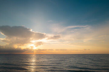Obraz premium Sea sunset with cloudy sky and sun through the clouds over. Clouds Ocean and sky background, seascape.