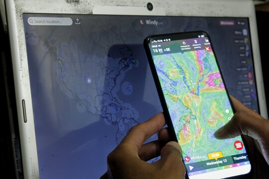 Klaten, Central Java - Indonesia - Nov 13, 2024: A person checking the Windy app. Windy is an interactive weather forecast app with wind, temperature, pressure, humidity and cloud information.
