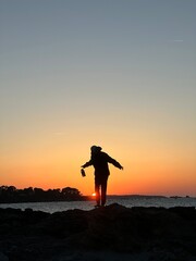 silhouette of a person on the beach after a long hiking day. 