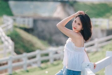 Naklejka premium Young woman posing gracefully in natural setting while enjoying the outdoors with a bright smile and relaxed style