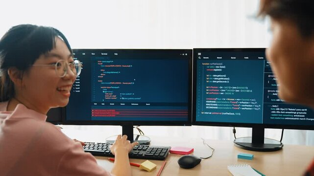 Slow motion back end software developer engineer for computer programming working together on debugging writing computing code, solving complex algorithms display on monitor in office. Burgeoning