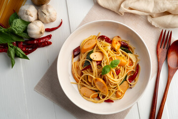 Spaghetti with Sausage and Dried Chili.Spicy stir fried Spaghetti with smoky bite ,garlic and crispy chilli in white plate.Top view.