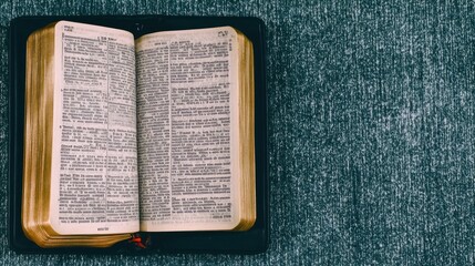 Obraz premium An open book on a textured surface, likely a Bible, emphasizing reading and reflection.
