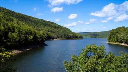 Beautiful lake or reservoir in Southern Catskills, New York State. Blue sky, white clouds, green...
