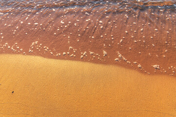 Soft wave of the sea on the sandy beach.