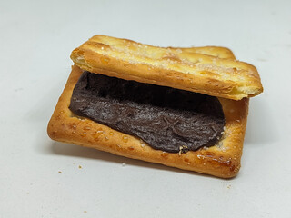 A tempting open view of a chocolate-filled biscuit, emphasizing the glossy chocolate against the...