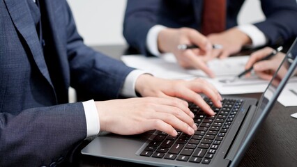 会議でタイピングをするビジネスパーソン