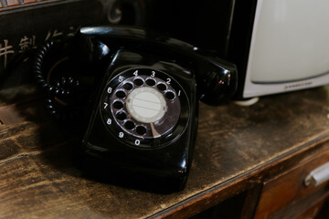 old black telephone phone on a wooden table, vintage decoration