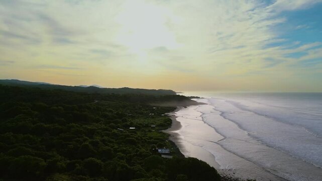 El Salvador beach aerial view of Punta Mango, El Cuco during early hours of the morning with silhouette of shoreside - Dolly In