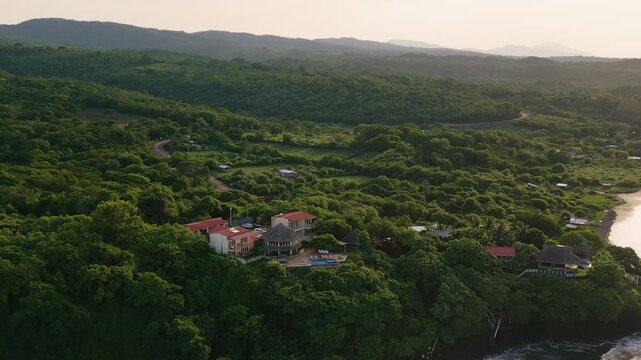 El Salvador Punta Mango beach panoramic aerial view of surrounding green nature foliage at beach resort in during early morning - Dolly In