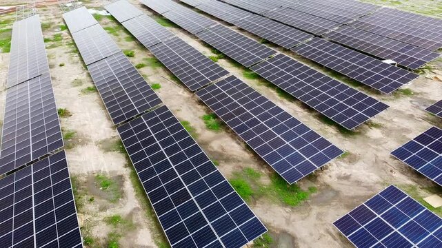 Aerial sliding right shot of new clean efficient bifacial solar panels at a solar park