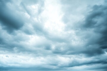 Obraz premium A low angle view of a cloudy sky with light shining through the clouds.