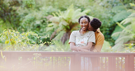 Kiss, hug and black couple on bridge in park for bonding, love connection and outdoor adventure. Commitment, man and woman on path in nature for romantic date, weekend embrace and happy green garden.