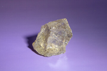macro photography geological collection - raw clear quartz rock crystal stone on light purple...