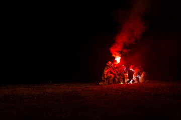 A group of military men in combat gear patrol in the middle of a desert and tropical jungle. Soldiers in full combat gear in dry weather conditions assemble and march on a mission.